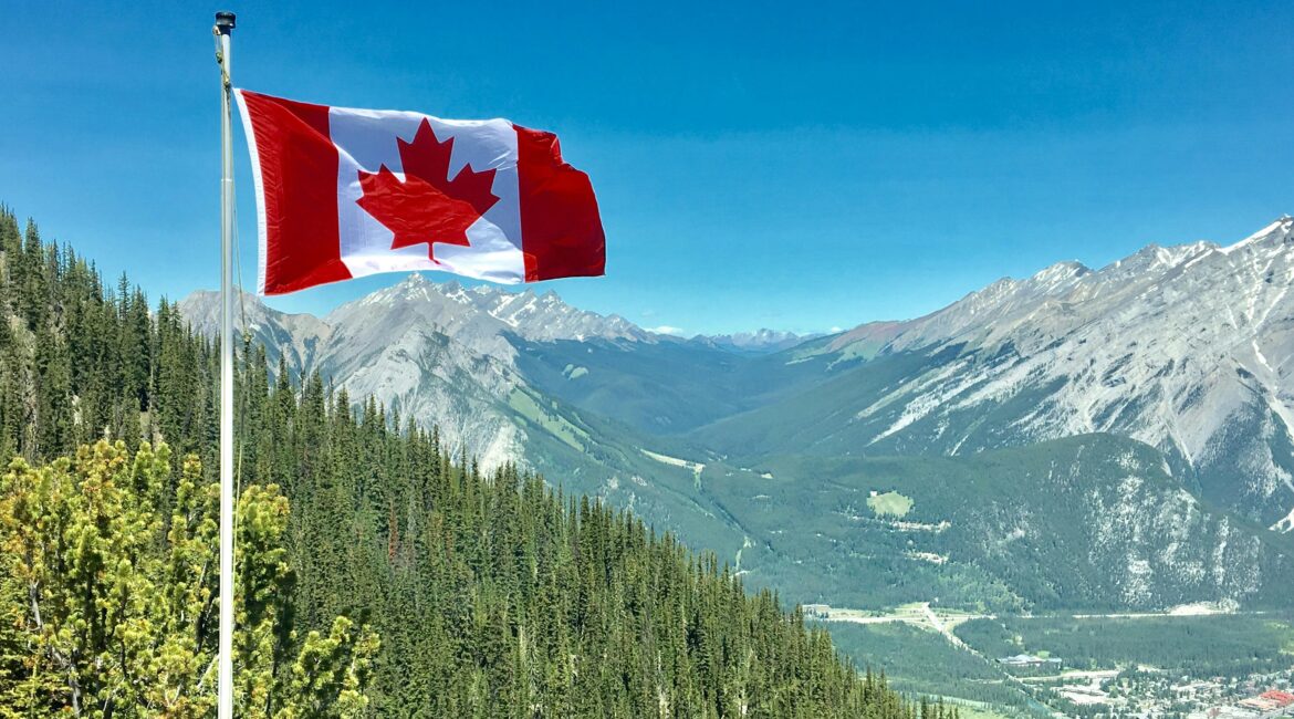 Photo by Daniel Joseph Petty: https://www.pexels.com/photo/canada-flag-with-mountain-range-view-756790/
